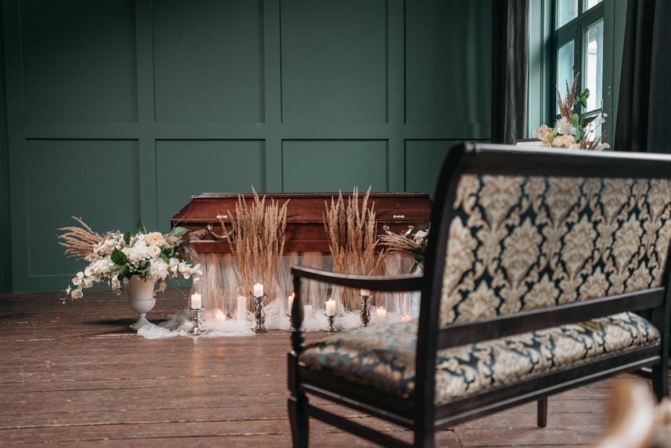 An elegant floral arrangement positioned in front of a closed wooden piano with a rich brown finish, featuring a variety of white and cream-colored flowers, including roses and lilies, complemented by